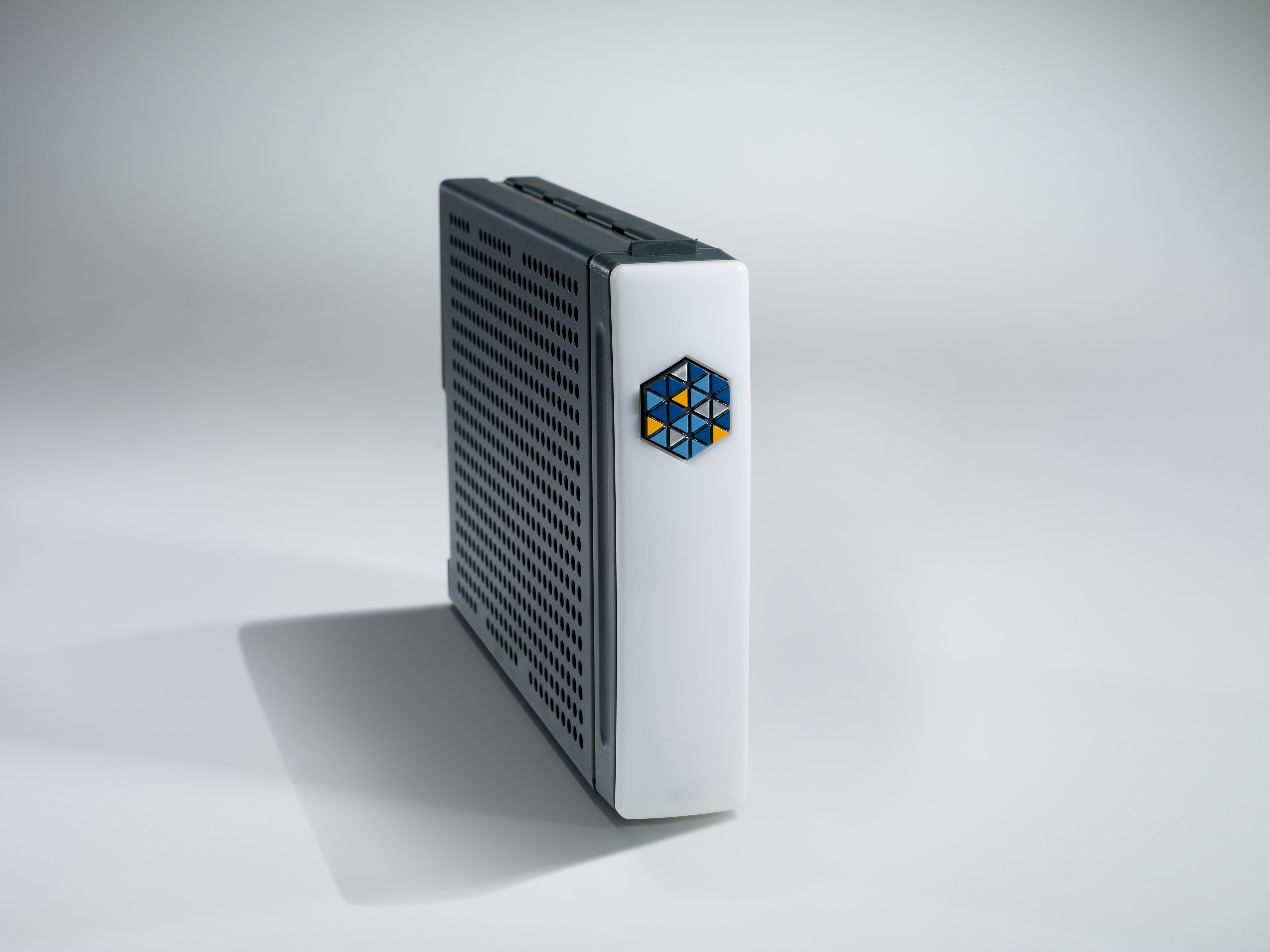 Low-profile Kaleidescape disk cartridge with a perforated metal housing and white front handle.