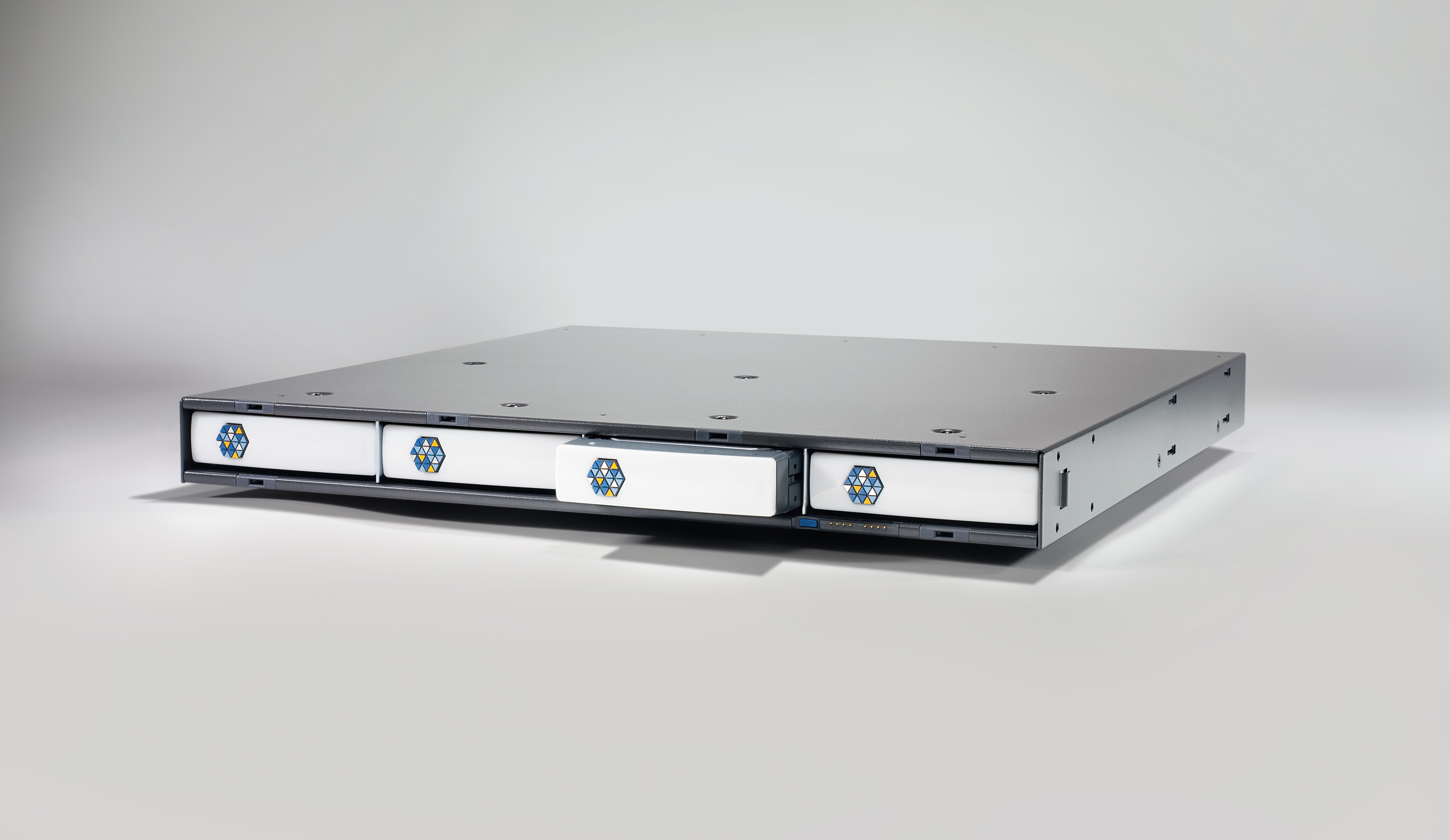 Kaleidescape 1U server with four front disk cartridges, one partly withdrawn, and side trim removed.