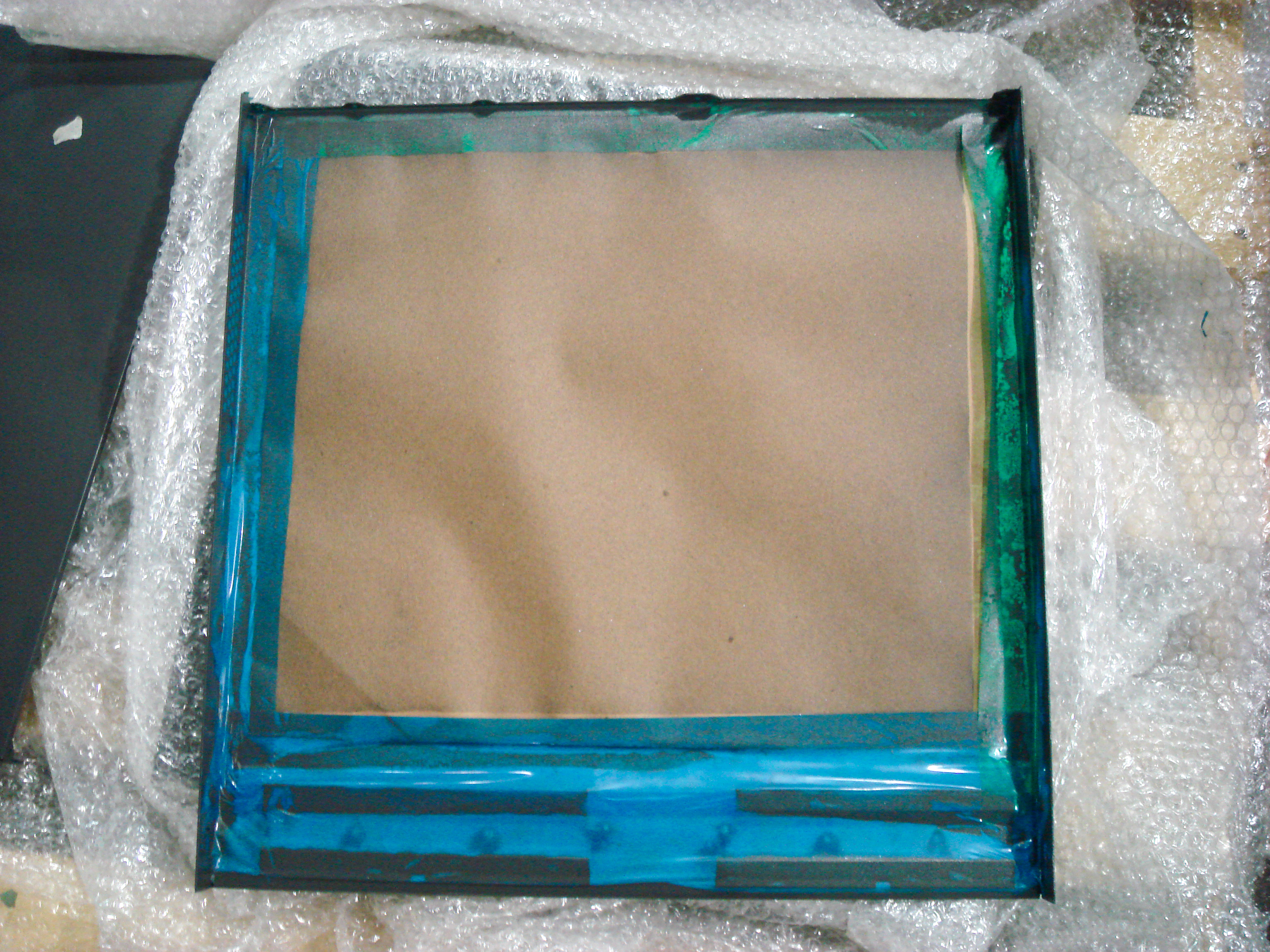 Sheet-metal panel with paper and tape masking; the image does not establish a throughput result.
